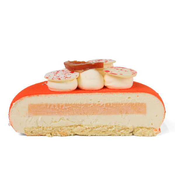 Cross-section of vibrant orange cake decorated with white icing dollops, and a piece of orange on top