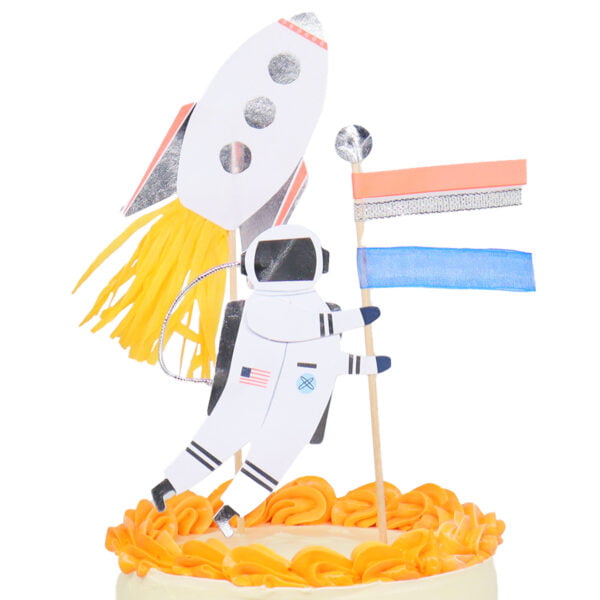A cake topper with an astronaut holding a flag and a rocket.