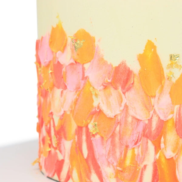 A close up of a pink and orange cake.