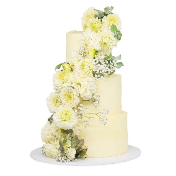 A three tier cake with white flowers and greenery.