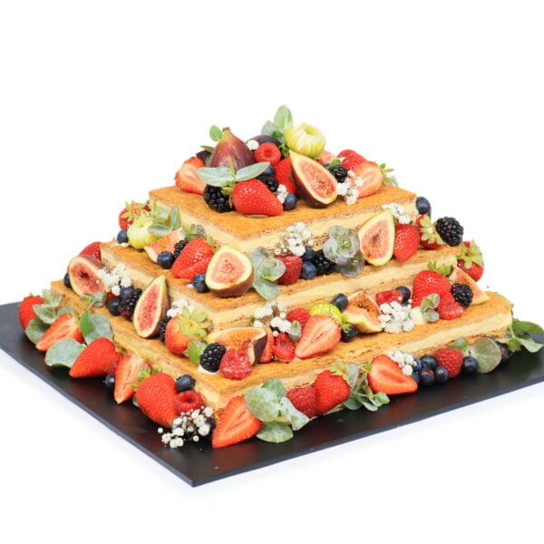 A pyramid shaped cake with berries and figs.