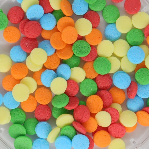 Colorful sprinkles in a bowl on a white surface.