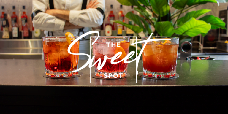 The sweet shop is a bar with three drinks in front of it.