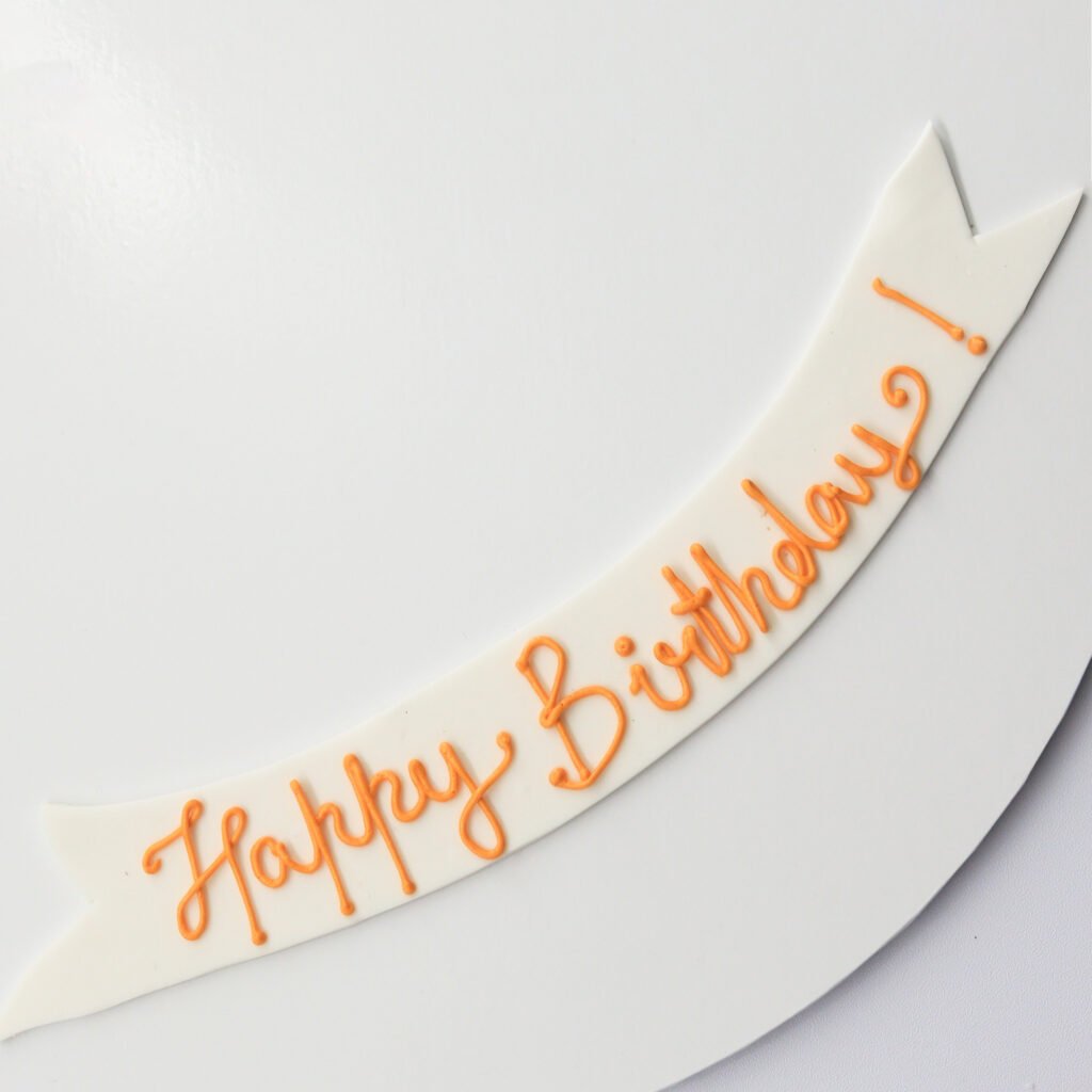 A cake with a banner that says happy birthday.