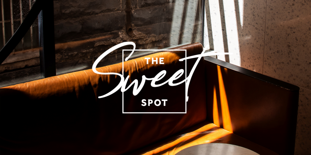 The sweet spot logo on a chair in front of a window.