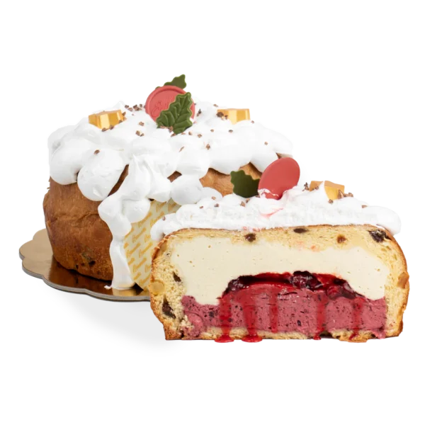 A cut panettone filled with cream and red berry compote, topped with whipped cream and festive decorations, on a reflective surface against a dark background.