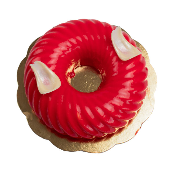 A vibrant red Strawberry Twist cake on a gold doily, with a circular shape.