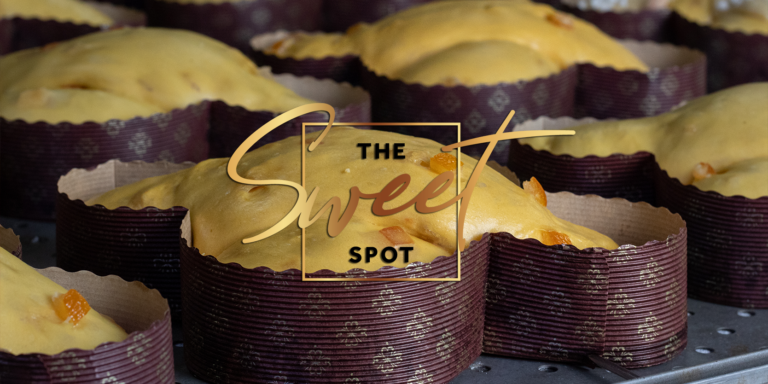 Freshly baked pastries in purple wrappers on a tray with a logo reading "the sweet spot" in a stylish font.