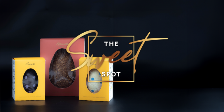 Product packaging for "the sweet spot" chocolates, featuring three boxes of white and dark chocolate easter eggs displayed against a dark background.