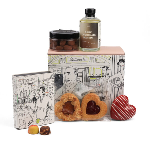 Assorted gourmet gift set including a dark chocolate martini bottle, chocolate truffles, heart-shaped cookies, and a decorative box with illustrated city scenes.