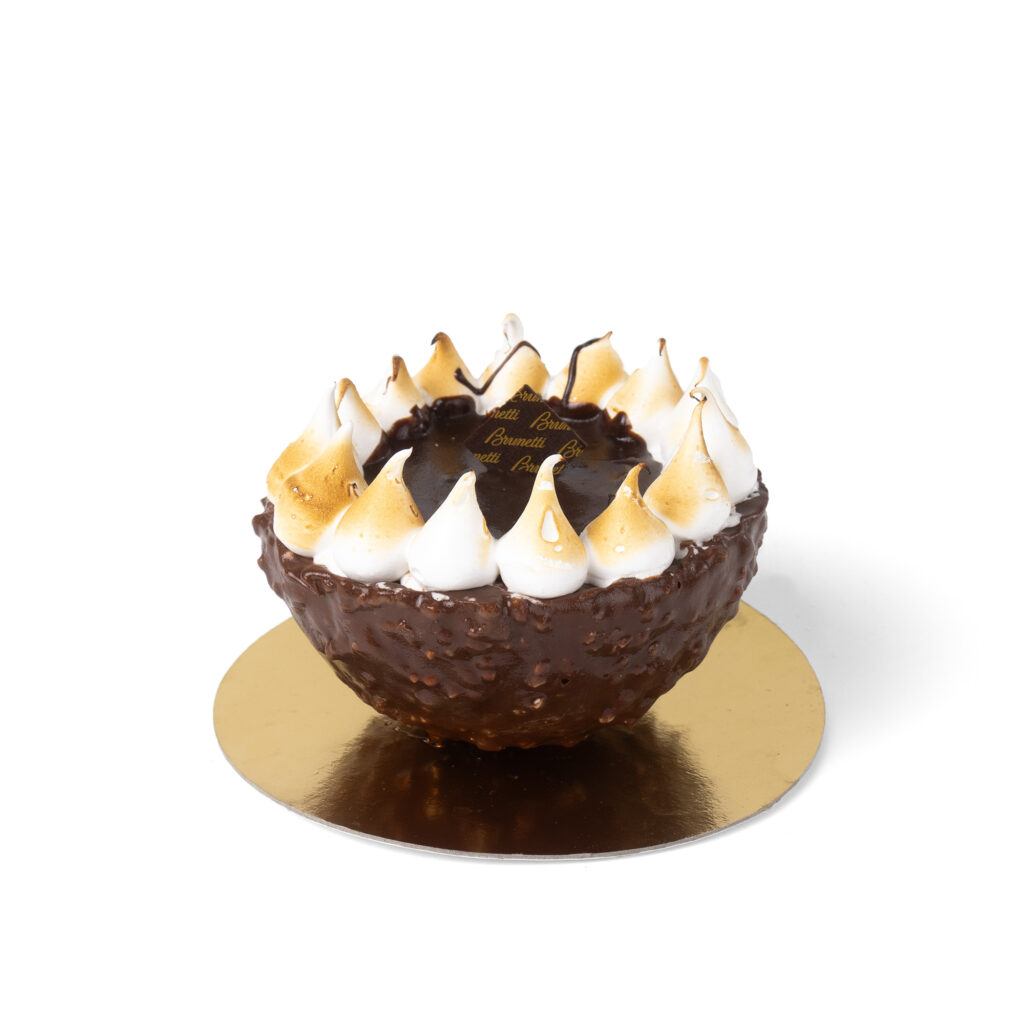 A chocolate dessert topped with swirls of toasted meringue on a gold base, isolated on a white background.