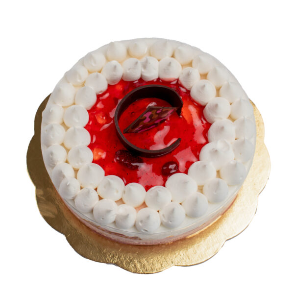 Vegan Fragola al Limone . Round cake with a creamy white frosting topped with a red jelly layer and decorative white meringue drops, presented on a gold base.