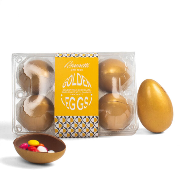 Packaging with three golden chocolate eggs and one half-open egg filled with colorful candies, all against a white background.