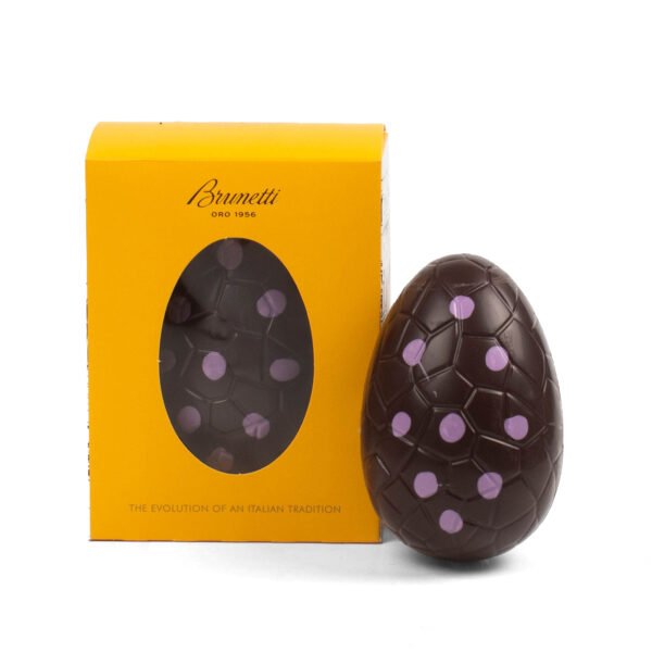 A brunetti chocolate easter egg with pink decorations, displayed next to its yellow packaging with a viewing window.